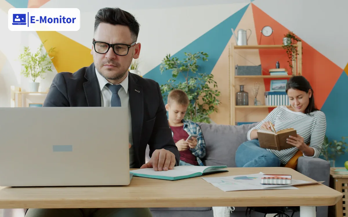 Employee working on a company laptop from home while family sits in the background